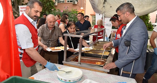 Koltuk değneği ile iftar yemeklerini doldurdu